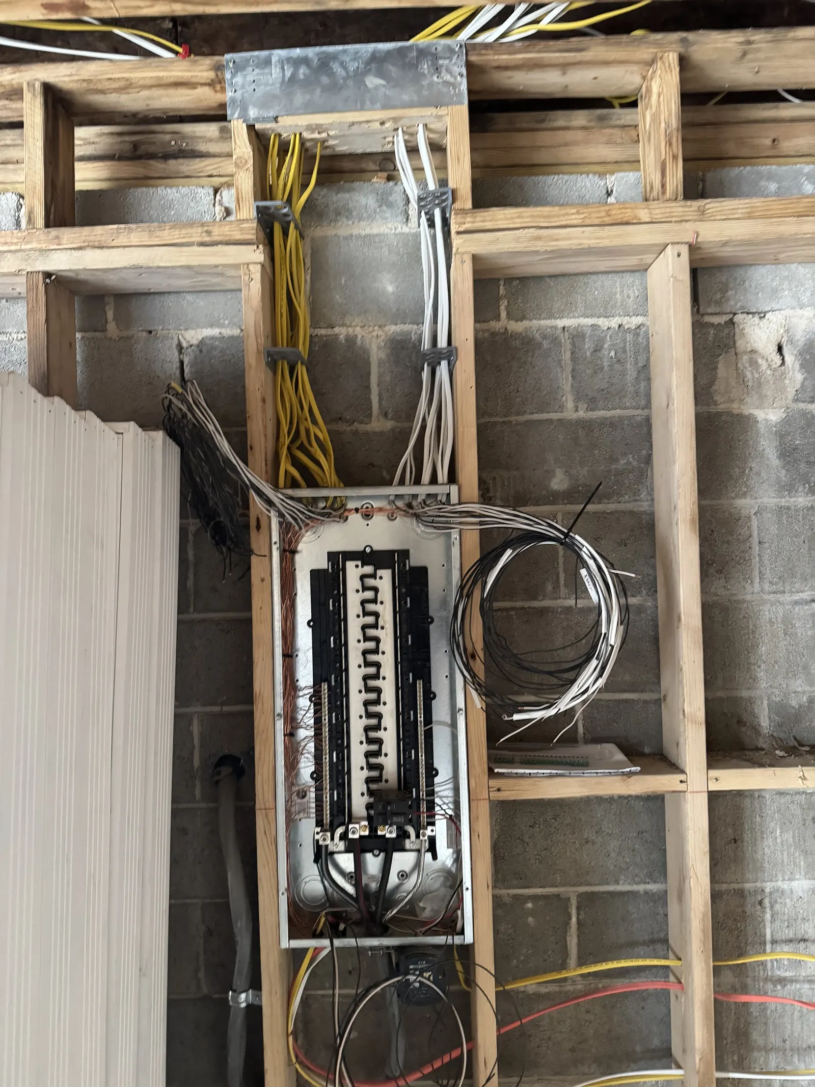 Open electrical panel with new wiring run through the framing